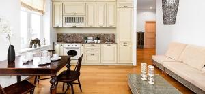 Una sala de estar con una mesa y una cocina. en Villa Lehe Ranna Apartment, en Pärnu