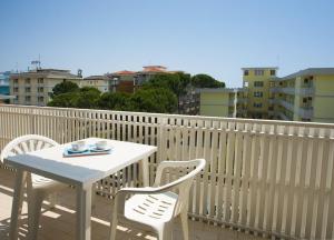 - Balcón con mesa blanca y sillas en Apartments in Bibione 24550, en Bibione
