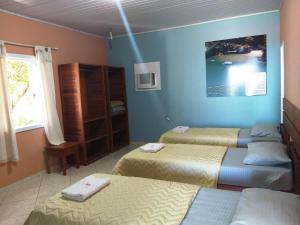 a room with three beds and a window at Pousada Platôdasilhas in Angra dos Reis