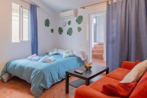 マラガにあるAPARTAMENTUM Ballesteros Málagaのベッドルーム1室(ベッド1台、ソファ、テーブル付)