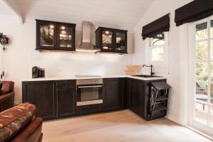 a kitchen with dark brown cabinets and a stove at Leddicott Cottage in Olinda