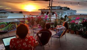 un grupo de personas sentadas en sillas viendo la puesta de sol en Hostel Vallarta, en Puerto Vallarta