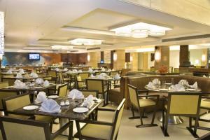 a restaurant with tables and chairs with napkins on them at The Sonnet Kolkata in Kolkata