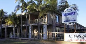 a resort with palm trees in front of a building at Huskisson Bayside Resort in Huskisson