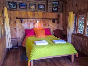 a bedroom with a bed in a wooden cabin at Hostal Mamá Hilda in Chugchilán