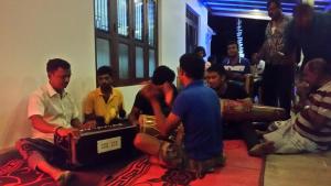 un groupe d'hommes assis à même le sol dans une pièce dans l'établissement Kandyan Rest, à Wasgamuwa