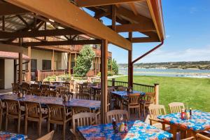 a restaurant with tables and chairs and a view of the water at Arrowwood Resort at Cedar Shore in Oacoma