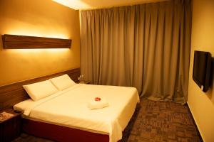 a hotel room with a bed and a television at De Botani Hotel in Ipoh