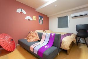 a bedroom with a bed and a chair and an umbrella at Miyabiro 105 in Kyoto