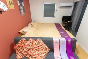 a small bedroom with a bed and a table with pillows at Miyabiro 105 in Kyoto
