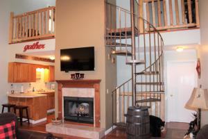 a living room with a fireplace and a spiral staircase at Spacious Downtown Condo Walking distance to Downtown Gatlinburg Sleeps 6 guests in Gatlinburg