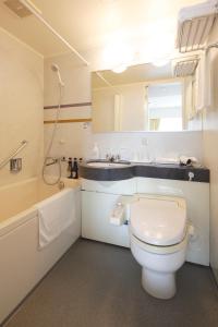 a bathroom with a white toilet and a sink at Hotel Garden Square Shizuoka in Shizuoka