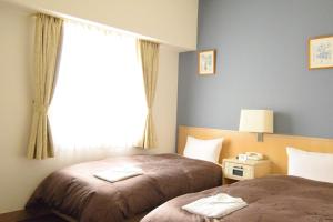 pokój hotelowy z 2 łóżkami i oknem w obiekcie Hotel Raffinato Sapporo w mieście Sapporo