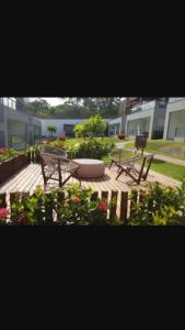 a patio with two benches and a table and flowers at Solaris Village Imbassaí in Imbassai