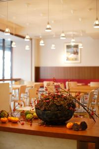 a table with a large bowl of fruit on it at Hotel Garden Square Shizuoka in Shizuoka