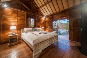 a bedroom with a bed in a room with wooden walls at The Lebak Canggu in Canggu +212 photos