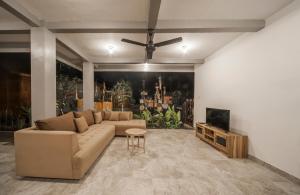 a living room with a couch and a flat screen tv at The Lebak Canggu in Canggu