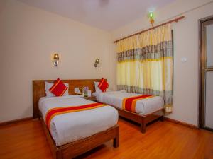 um quarto de hotel com duas camas e uma janela em Hotel Garuda Inn em Pokhara