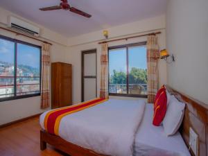 um quarto com uma cama e 2 janelas grandes em Hotel Garuda Inn em Pokhara