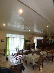 a dining room with tables and chairs and a room at Taklam Lodge And Tours in Kokopo