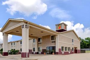 a large building with a clock on top of it at Super 8 by Wyndham Waxahachie TX in Waxahachie