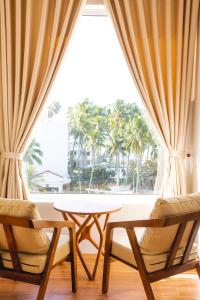 una mesa y dos sillas frente a una ventana en Mui Ne Beach Hotel, en Mui Ne