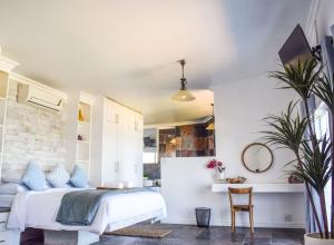 a bedroom with a bed and a table at Santorini Guesthouse in Amanzimtoti