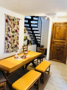 a dining room with a table and chairs and a staircase at La casetta di Giuci in Imperia