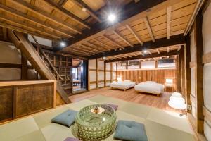 a large room with two beds and a table at NIPPONIA Sawara Merchant Town Hotel in Katori