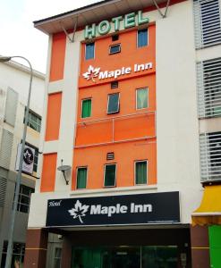a hotel with an orange and white building at Maple Inn in Kuala Lumpur