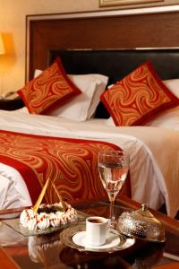 a hotel room with a bed and a table with a dessert on it at Buyukhanli Park Hotel in Ankara