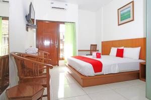Schlafzimmer mit einem Bett, einem Schreibtisch und einem Bett in der Unterkunft RedDoorz @ Turangga Sari in Yogyakarta