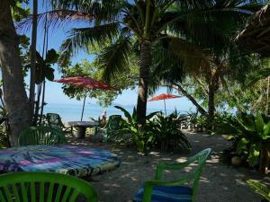 a patio with chairs and a table and umbrella at Dugong Koh Sukorn in Ko Sukon