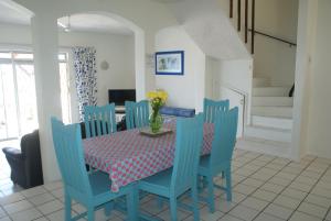 uma sala de jantar com uma mesa e cadeiras azuis em Rosscarbery 2 em Margate