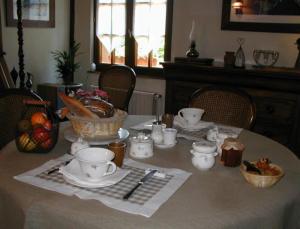 una mesa con un set de té encima en Chambres d'hôtes La Petite Flambée, en Le Tronquay