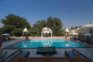 a large swimming pool with a gazebo at Alsisar Mahal- Heritage Hotel in Alsīsar
