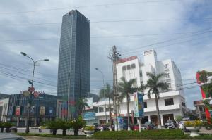 a city street with a tall skyscraper at Bình Minh Hotel in Hà Tĩnh