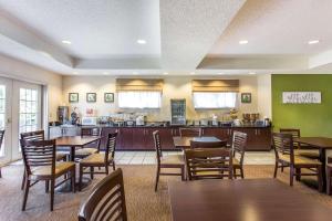 a restaurant with tables and chairs and a kitchen at Sleep Inn & Suites North Augusta in North Augusta
