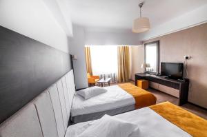 a hotel room with two beds and a television at Hotel Europeca in Craiova