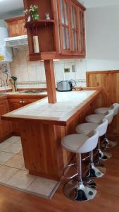 cocina con barra con taburetes en Depto Parque Suizo 800, en Pucón 10 fotos más
