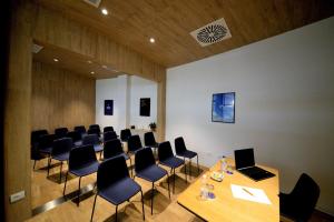 a conference room with chairs and a table with a laptop at Air Rooms Rome Airport by HelloSky in Fiumicino