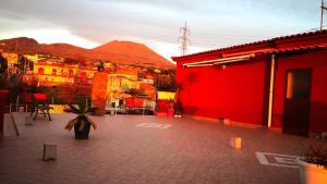 czerwony budynek z doniczką na dziedzińcu w obiekcie La casetta di Ester w mieście Ercolano