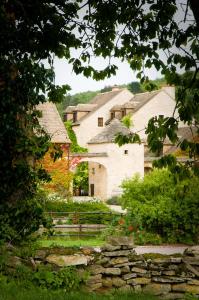 um grupo de edifícios com uma parede de pedra em Le Hameau de Barboron em Savigny-lès-Beaune