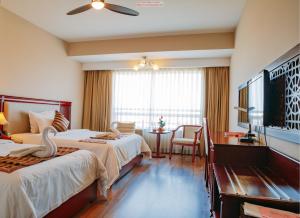 ダナンにあるMinh Toan Athena Hotelのベッド2台、薄型テレビが備わるホテルルームです。