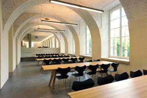 una fila de mesas y sillas en una habitación con ventanas en Basel Youth Hostel, en Basilea