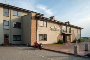 a motorcycle parked in front of a building at Villa Alicante & SPA in Zujūnai