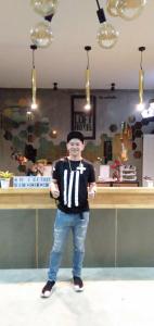 a man is standing in front of a bar at PJ Loft Hotel in Ban Khok Krathin