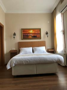 a bedroom with a bed with a painting on the wall at Ottoman's Pearl Hotel in Istanbul