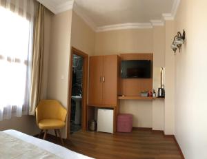 a bedroom with a bed and a tv and a chair at Ottoman's Pearl Hotel in Istanbul