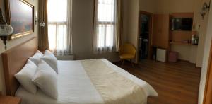 a bedroom with a large bed with white sheets and pillows at Ottoman's Pearl Hotel in Istanbul